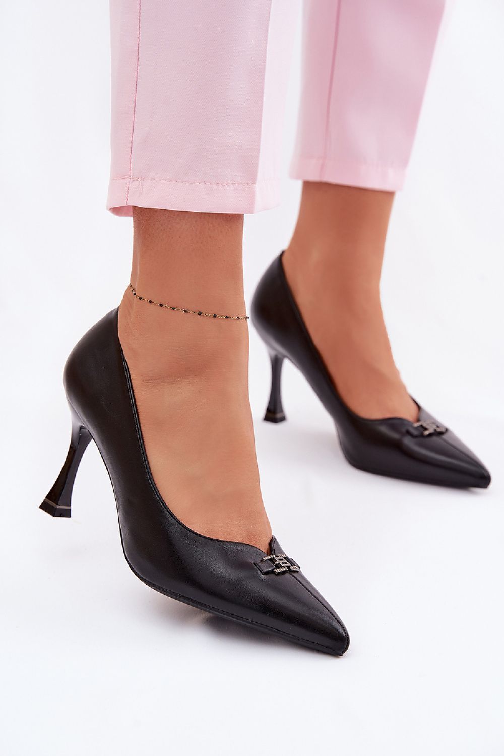 Black high heels worn with pink trousers, showcasing Arabelle Elegant Women's Pumps in a stylish setting.