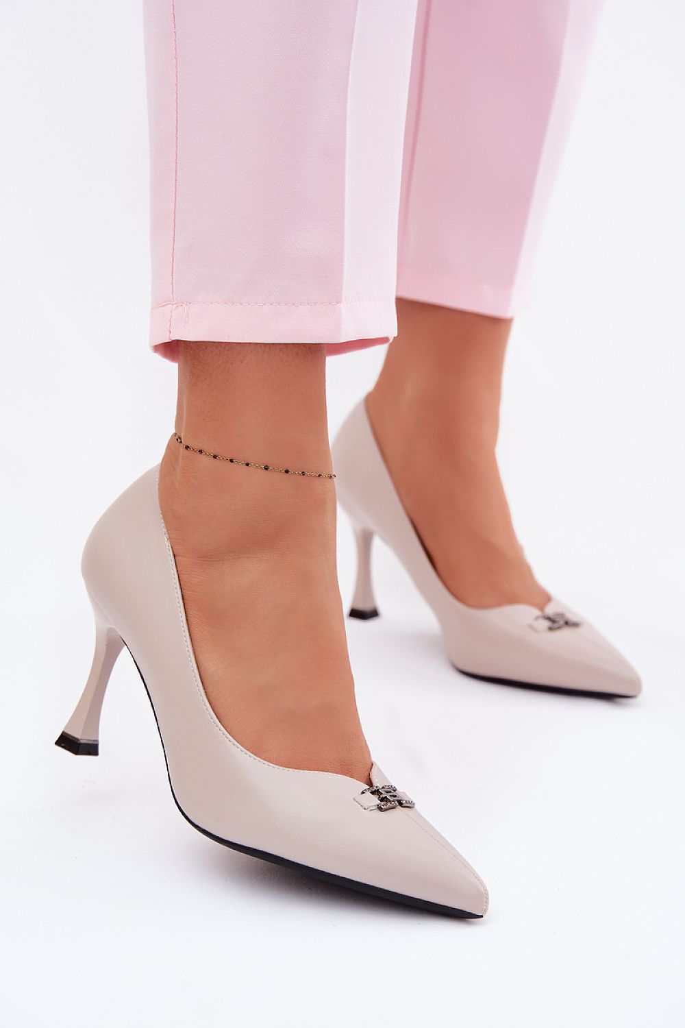 Grey pointed toe heels Valeria pumps worn with pink trousers, showcasing elegant design and decorative front detail.